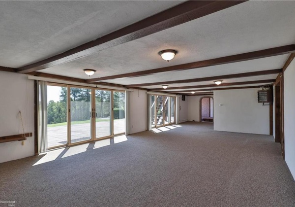 Sun room with entry to hot tub room, two full bathrooms and sauna. Multiple sliding glass doors to ground level patio.