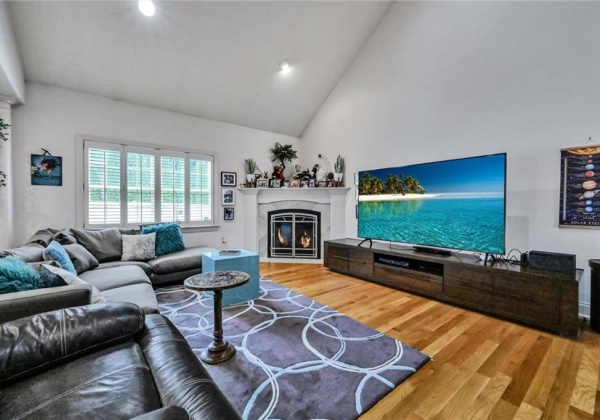 Great room with gleaming hardwood floors and custom corner fireplace