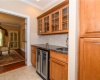 Wet bar between dining room and kitchen with wine refrigerator and sink