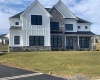 Curb appeal enhanced by lovely mix of black windows, vertical Hardy Board siding, metal porch roofs