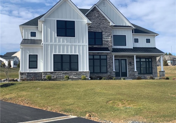 Curb appeal enhanced by lovely mix of black windows, vertical Hardy Board siding, metal porch roofs