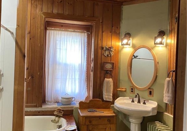 First floor bathroom with bathtub and new walk-in shower with bench.