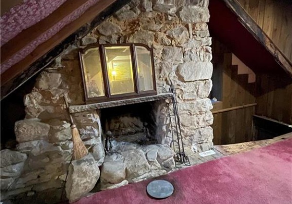 Stone fireplace in room above the kitchen.