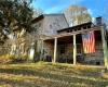 Side angle of house with covered front porch.