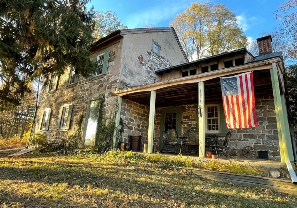 Side angle of house with covered front porch.