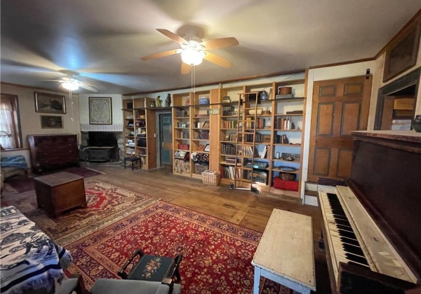 Living room with built-in bookshelves, wooden rolling library ladder and woodstove.