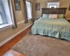 Primary Bedroom with same beautifully restored floors and bead board ceilings