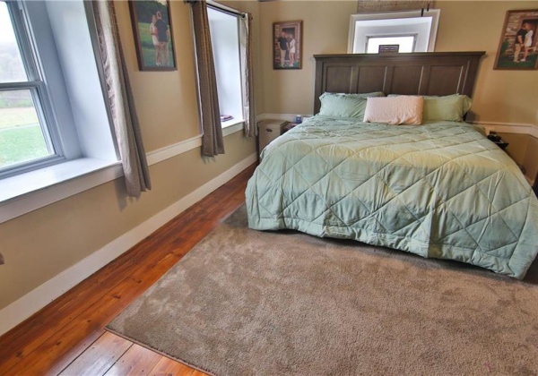 Primary Bedroom with same beautifully restored floors and bead board ceilings